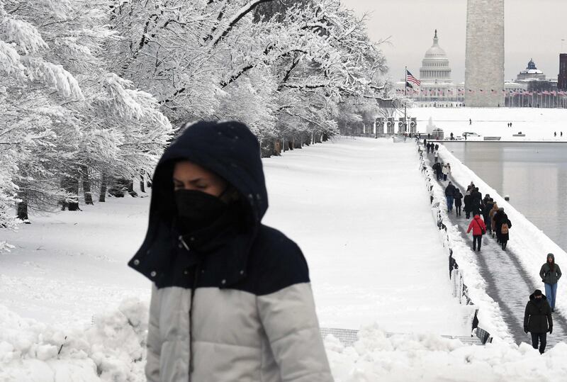 People walk past the Reflecting Pool at the Lincoln Memorial on the National Mall after the winter storm. AFP