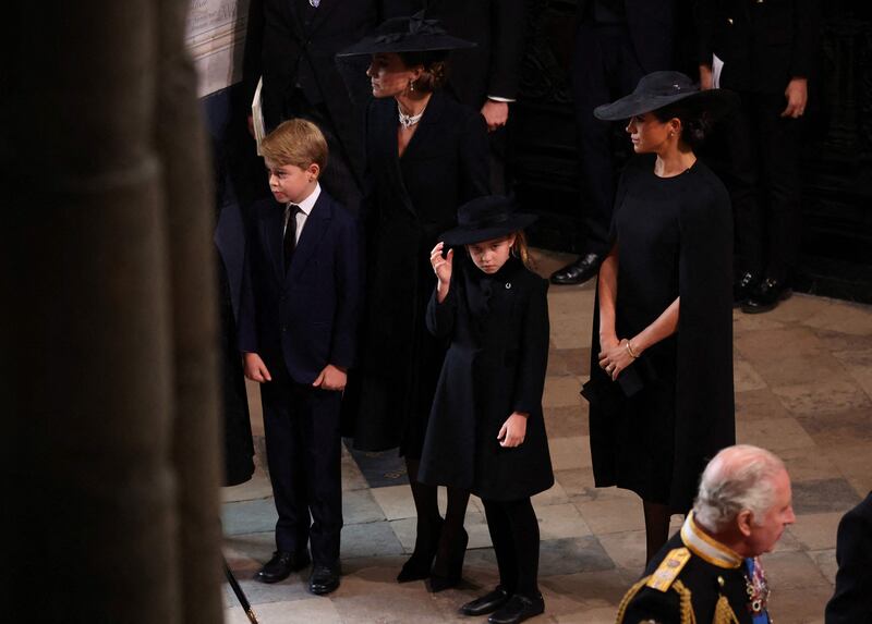 Catherine, Princess of Wales, and Meghan, Duchess of Sussex, usher Prince George and Princess Charlotte into Westminster Abbey for the queen's funeral on Monday, with King Charles in the foreground on the right. AFP