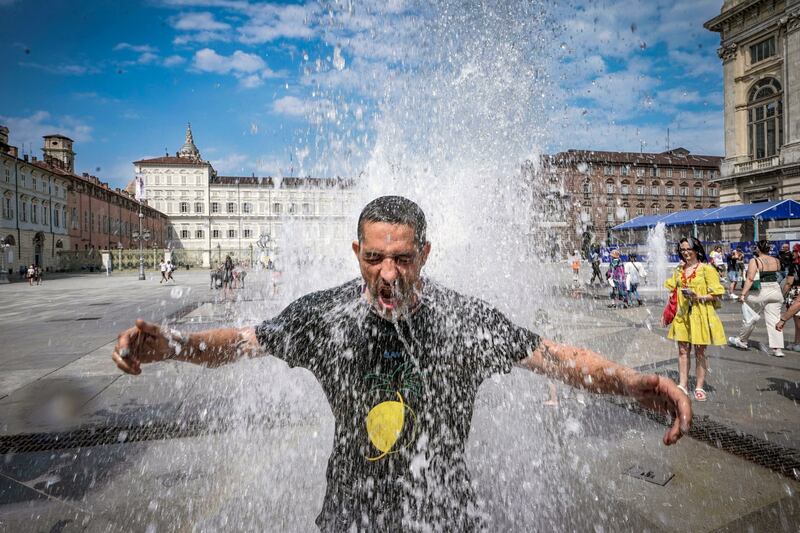 A man cools off in a fountain during a heat wave in Turin, Italy.    EPA 