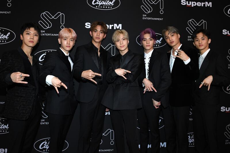 TOPSHOT - Members of K-pop supergroup SuperM pose during a press conference at the Capitol Records Tower in Hollywood on October 3, 2019. / AFP / VALERIE MACON
