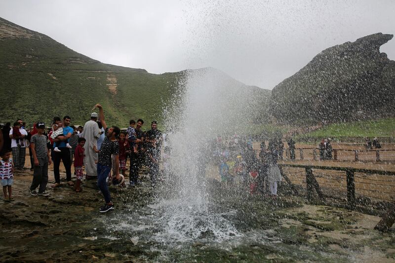 A man snaps a selfie in front of a blowhole erupting with water from the Arabian Sea at Al Mughsayl.