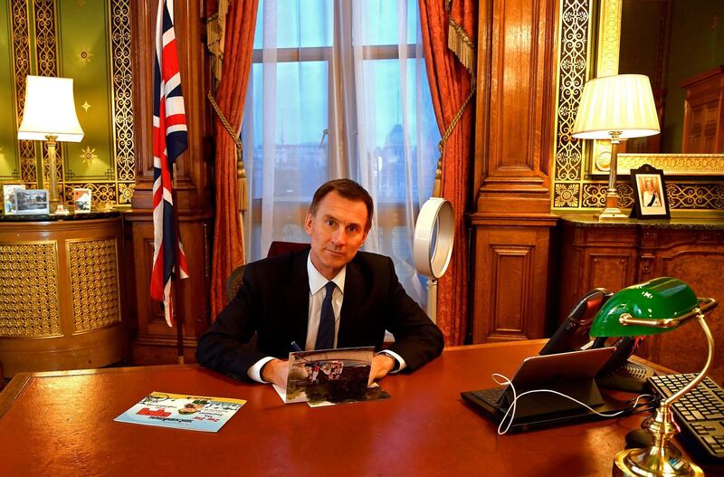 Britain's Foreign Secretary Jeremy Hunt is seen with a copy of "Jay Jay the Journalist" written by Wa Lone, one of two Reuters reporters currently imprisoned in Myanmar, whilst working in his office in London, Britain, December 20, 2018. Picture taken December 20, 2018.  REUTERS/Toby Melville