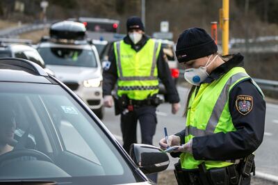 ISCHGL, AUSTRIA - MARCH 13: A police officer at a roadblock asks the driver of a car driving out of the Panznautal valley for a drive through permission following the imposition of a quarantine due to the coronavirus on March 14, 2020 near Ischgl, Austria. The ski resort towns of Sankt Anton and Ischgl are both under quarantine and many ski resorts in the region have been closed. The Austrian government is pursuing aggressive measures, including closing schools, cancelling events and shuttering shops except for grocery stores and pharmacies in an effort to slow the ongoing spread of the coronavirus. (Photo by Jan Hetfleisch/Getty Images)