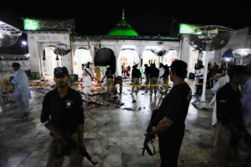 Pakistani security officials examine the site of suicide bomb attacks at Sufi saint Hazrat Syed ali bin Usman Hajweri, popularly known as Data Ganj Bakhsh, in Lahore on Friday, July 2, 2010.