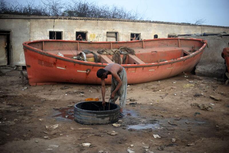 Wash time: A shipyard worker pulls water from a well to clean himself after another long and hard shift.
