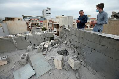 People stand next to a roof damaged after a rocket attack on U.S.-led forces in and near Erbil International Airport last night, in Erbil, Iraq February 16, 2021. REUTERS/Azad Lashkari