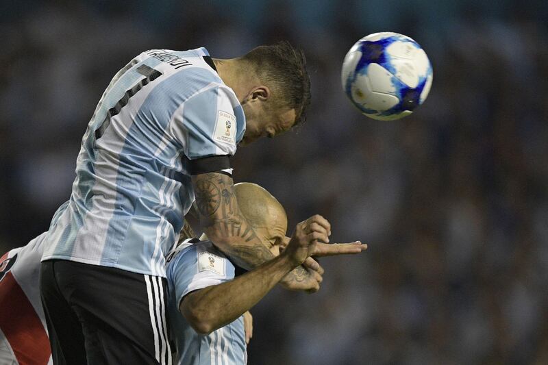 Argentina's Nicolas Otamendi (top) heads the ball during the 2018 World Cup qualifier football match against Peru in Buenos Aires on October 5, 2017. / AFP PHOTO / Juan MABROMATA
