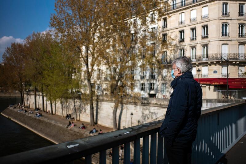 A man walks by the Seine river bank, in Paris, France. AP Photo
