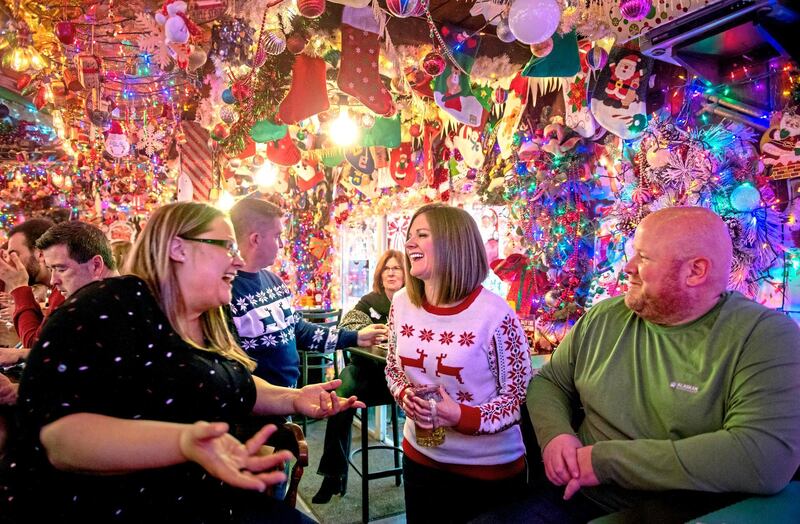 Friends follow a holiday tradition by gathering under approximately 10,000 lights decorating Bob's Garage in O'Hara Township, Pittsburgh.  AP