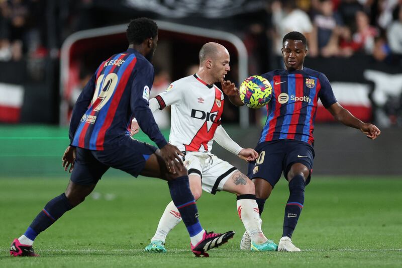 Rayo Vallecano forward Isi Palazon fights for the ball with Barcelona's Franck Kessie, left, and Ansu Fati. AFP