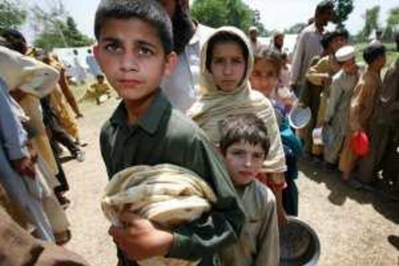 Children line up to receive food in a refugee camp near Mardan, in northwest Pakistan, Saturday, May 9, 2009. Hundreds of thousands of residents have fled fighting in the northwestern Swat Valley area after a new military offensive began against Taliban militants. (AP Photo/Greg Baker) *** Local Caption ***  XGB110_Pakistan.jpg