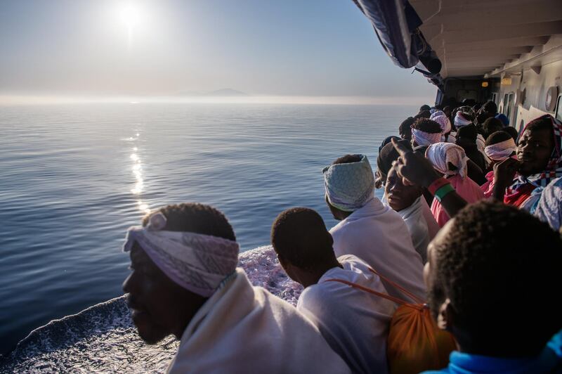 epa06686662 Migrants watch the Sicilian coast from the 'Aquarius' vessel as they arrive in Trapani, western Sicilia, Italy, 23 April 2018. Some 540 migrants were rescued by members of the NGO 'SOS Mediterranee' during 3 rescues operations about 50 kilometers off the Libyan coast, in the Mediterranean Sea. The migrants will be landed and registered in Trapani and transferred to centers before their case is studied.  EPA/CHRISTOPHE PETIT TESSON