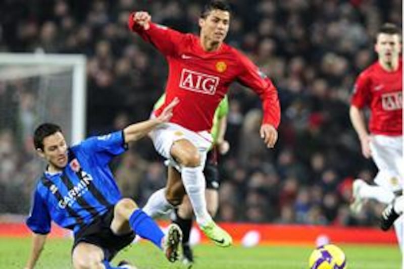Cristiano Ronaldo, centre, hurdles the challenge of Middlesbrough's Stewart Downing.