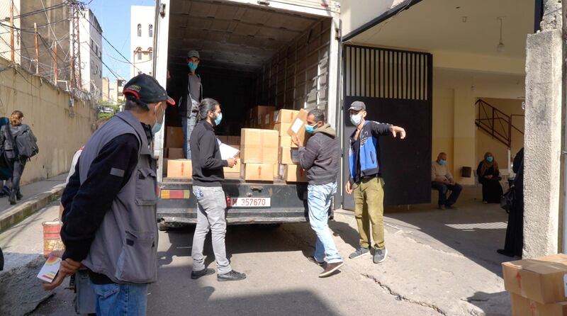 Volunteers and workers unload food for distribution at an NGO in Beirut as more and more Lebanese turn to handouts to survive. Mahmoud Rida