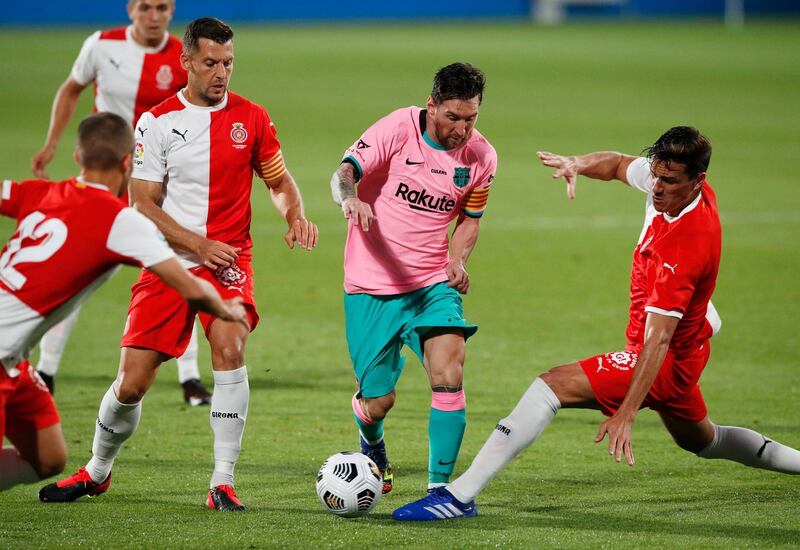 Three Girona players try to stop Lionel Messi. Reuters