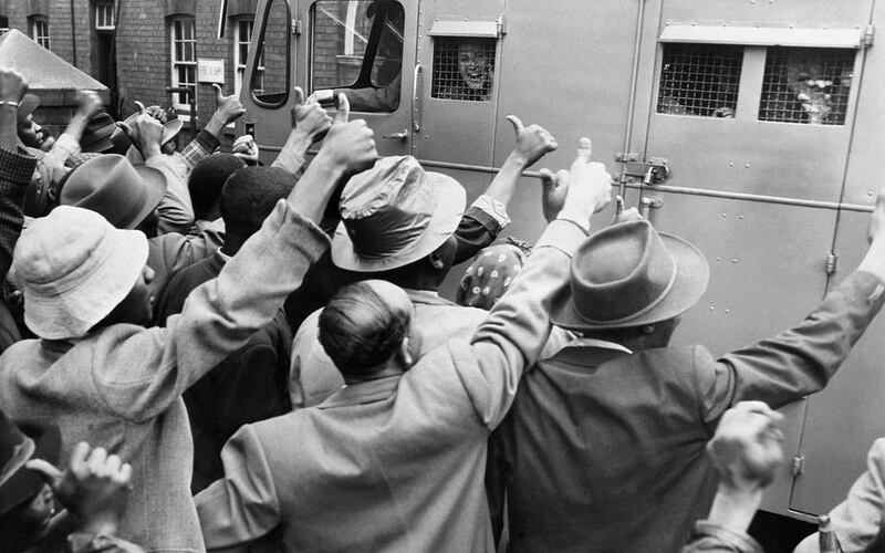 1956 - ANC supporters give the thumb up as a prison van with anti-apartheid militants go to Johannesburg’s courthouse, 28 December 1956. 152 anti-apartheid militants, in which Nelson Mandela, are on trial in Johannesburg. AFP PHOTO