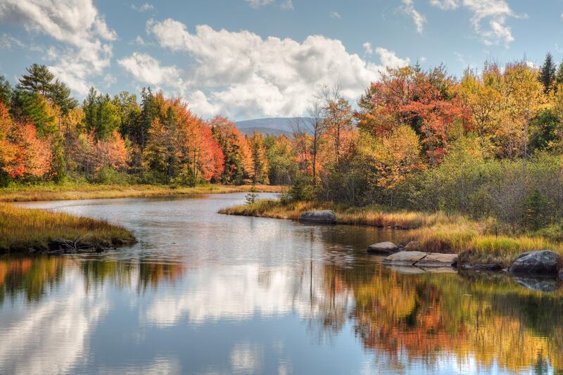 Very colorful orange, Yellow and Red Autumn Foliage Along Winding Northeast River with Blue Skies and White Clouds Reflected in River and Mountains in the Distance.  Bar Harbor Maine Near Acadia National Park. (Getty Images) *** Local Caption ***  ut29se-top10-usa.jpg