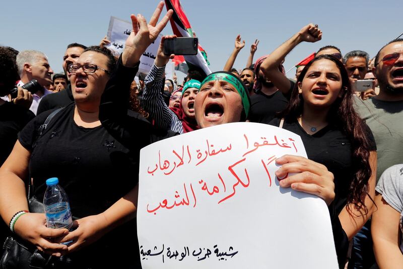 FILE PHOTO: Protestors chant slogans during a demonstration near the Israeli embassy in Amman, Jordan July 28, 2017. The poster reads "Close the terrorist embassy, dignity for the people". REUTERS/Muhammad Hamed/File Photo
