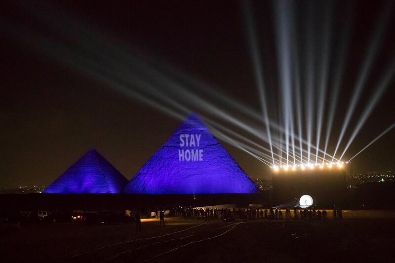 The Great pyramids lighten-up with blue light and reading with a laser projection the message "Stay Home" on the Giza plateau outside the Egyptian capital of Cairo. AFP