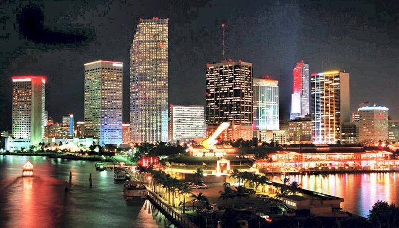 The skyline of Miami glows brightly 07 December two days before it will be hosting the Summit of the Americas, scheduled 09 -11 December. Thirty four heads of state will meet in Miami to discuss hemispheric issues. (COLOR KEY: Red on skyskraper-L-). (Photo by DOUG COLLIER / AFP)