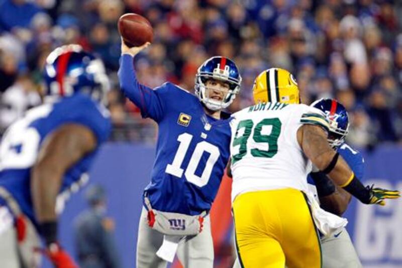 New York Giants' Eli Manning throws under pressure from Green Bay Packers