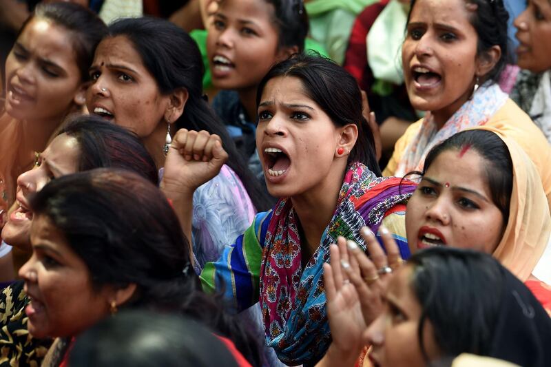 Indian women sit during a protest organised by 'Delhi Commission for Women' in New Delhi on April 13, 2018, outside Raj Ghat, memorial for Indian independence icon Mahatama Gandhi.
The brutal gang rape and murder of an eight-year-old girl in India has triggered nationwide outrage, inflamed communal tensions and shone a fresh critical light on the prevalence of sexual crimes. / AFP PHOTO / MONEY SHARMA