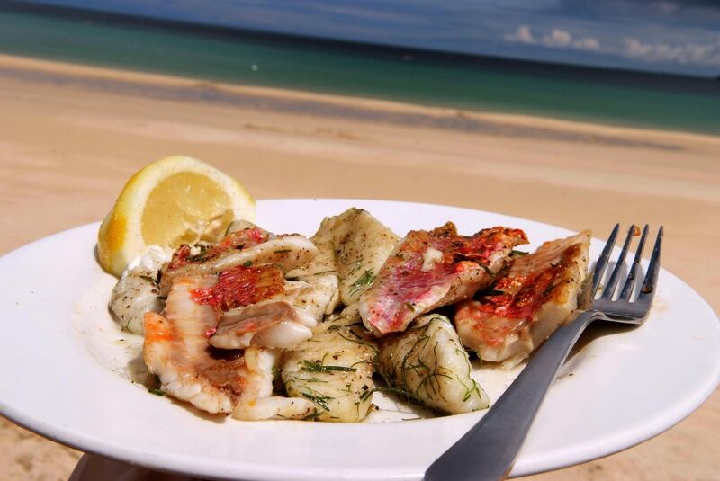 PH5MKM Tom & Amber Aikens cooking fish on a portable barbecue on the beach at Carbis Bay, Cornwall, UK