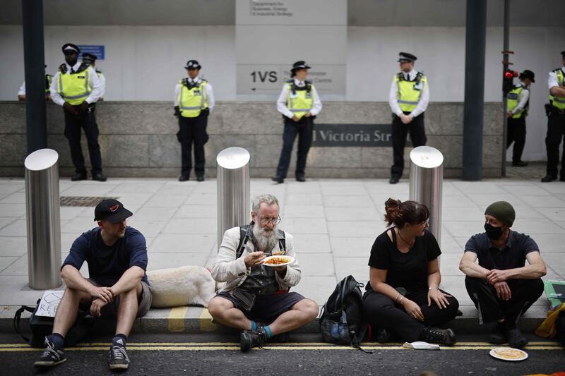 Climate activists take a break to have a snack in central London. AFP