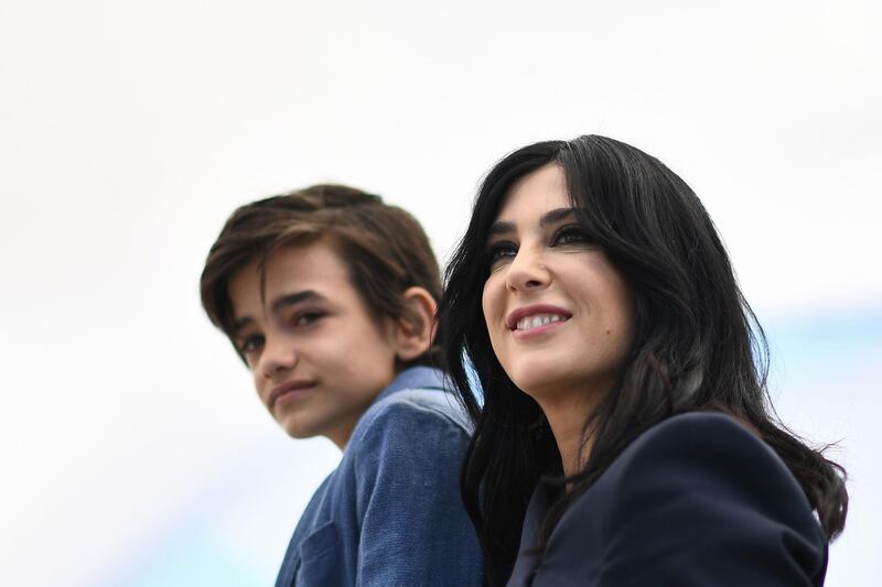 TOPSHOT - Syrian actor Zain al-Rafeea (L) and Lebanese director and actress Nadine Labaki pose on May 18, 2018 during a photocall for the film "Capharnaum" at the 71st edition of the Cannes Film Festival in Cannes, southern France.  / AFP / Anne-Christine POUJOULAT            
