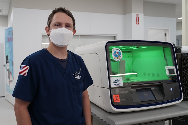 Matthew Tugwell poses next to a machine that extracts mRNA. Willy Lowry / The National