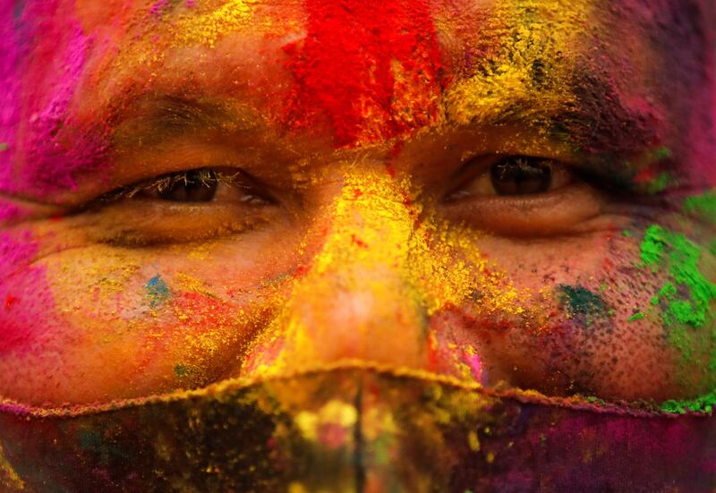 A man with his face smeared with coloured powder wears a protective face mask as he celebrates Holi, the festival of colours, amidst the spread of the coronavirus disease, in Kathmandu, Nepal. Reuters