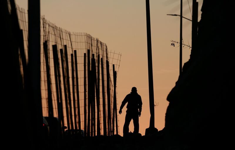 TIJUANA, MEXICO - JANUARY 7: A man walks along a road next to the U.S.-Mexico border wall on January 7, 2019 in Tijuana, Mexico. President Donald Trump, who is planning on visiting the border on Thursday, is considering declaring a national emergency if Democrats do not approve of 5.7 billion dollars in funding to build a wall. (Photo by Sandy Huffaker/Getty Images) ***BESTPIX***