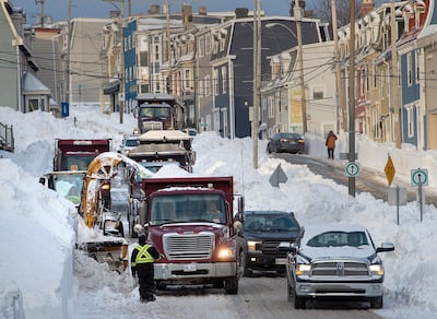 Workers continue to remove snow from the streets in St. John's, Newfoundland and Labrador, on Tuesday, Jan. 21, 2020. The state of emergency ordered by the City of St. John's continues for a fifth day, leaving most businesses closed and most vehicles off the roads in the aftermath of the major winter storm that hit the Newfoundland and Labrador capital. The city has allowed grocery and convenience stores to open for limited hours to let residents restock their food supply. (Andrew Vaughan/The Canadian Press via AP)