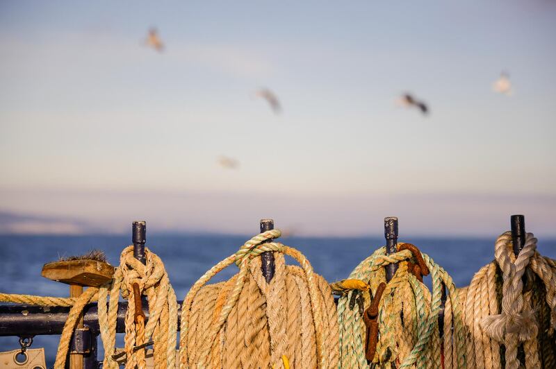 Coiled ropes hang from posts aboard fishing boat 'About Time'. Bloomberg