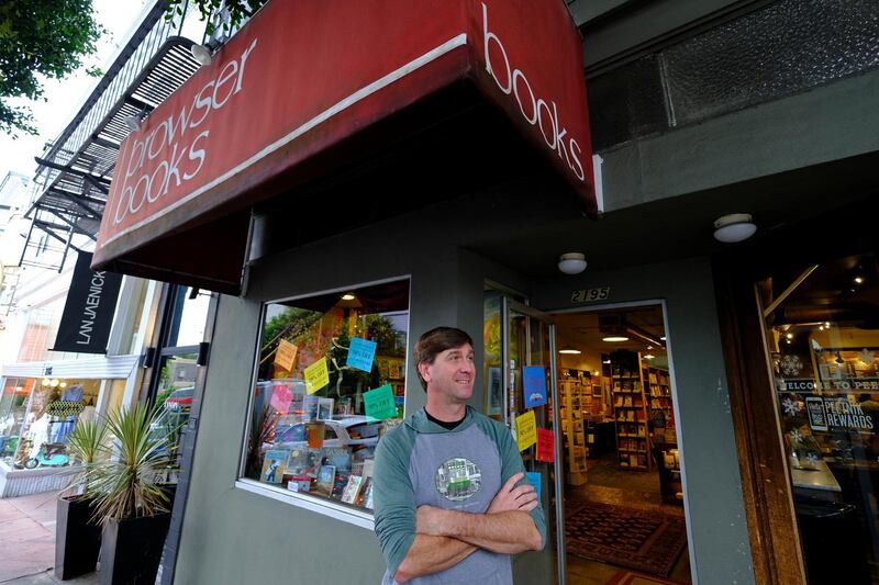In this Wednesday, Dec. 4, 2019, photo Pete Mulvihill poses for a photo while standing outside at his Browser Books store that he recently opened in San Francisco. Mulvihill has felt optimistic enough about being an independent bookseller that he bought a third store within the past two months. (AP Photo/Eric Risberg)