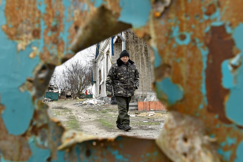 A man walks in his yard, damaged by shelling, in the village of Andriivka, Ukraine. EPA