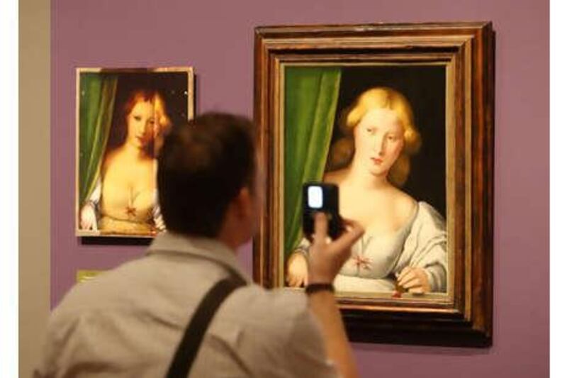 A visitor to the National Gallery in London views altered (left) and restored versions of Woman at a Window (unknown artist, c. 1510-1530), part of the Close Examination: Fakes, Mistakes and Discoveries exhibition.