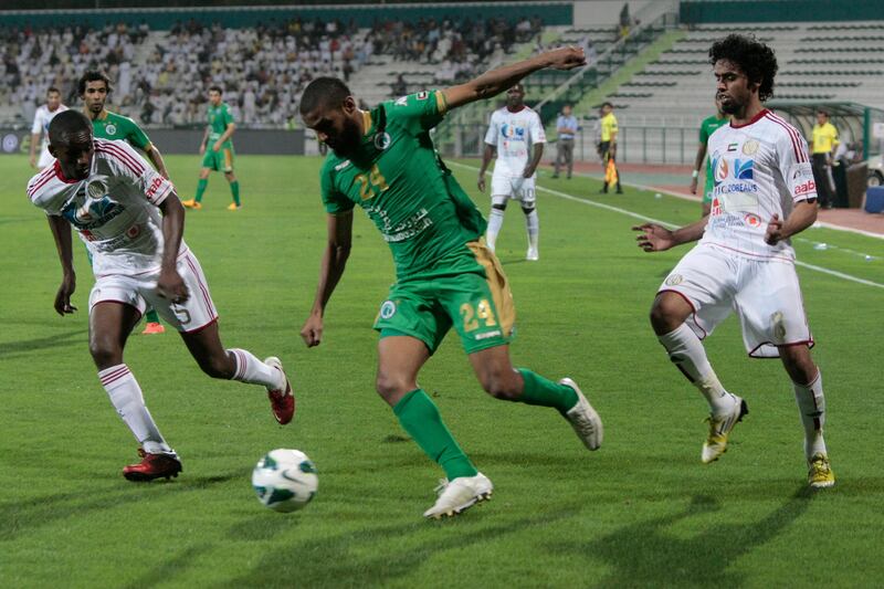 Dubai, United Arab Emirates - April 15, 2013.  Essa Obaid ( no 24 of Al Shabab in green uniform ) in action against Sami Rubaiya ( no 5 of Al Jazira in white uniform ) and Abdulla Qasem ( no 8 of Al Jazira in white uniform ) at their ongoing match for the Etisalat Pro League.  ( Jeffrey E Biteng / The National )