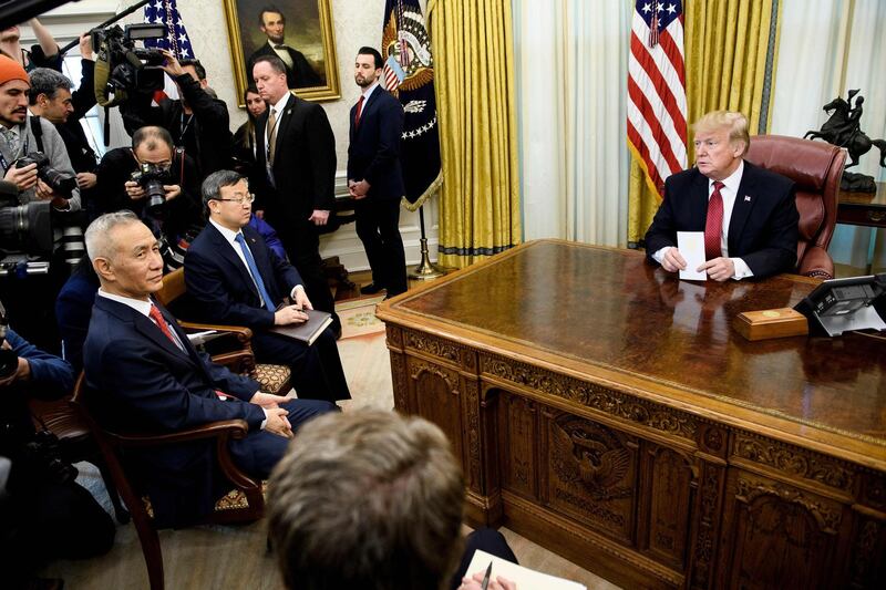 China's Vice Premier Liu He (L) and US President Donald Trump wait with others for a meeting between US and Chinese officials in the Oval Office of the White House January 31, 2019 in Washington, DC. / AFP / Brendan Smialowski
