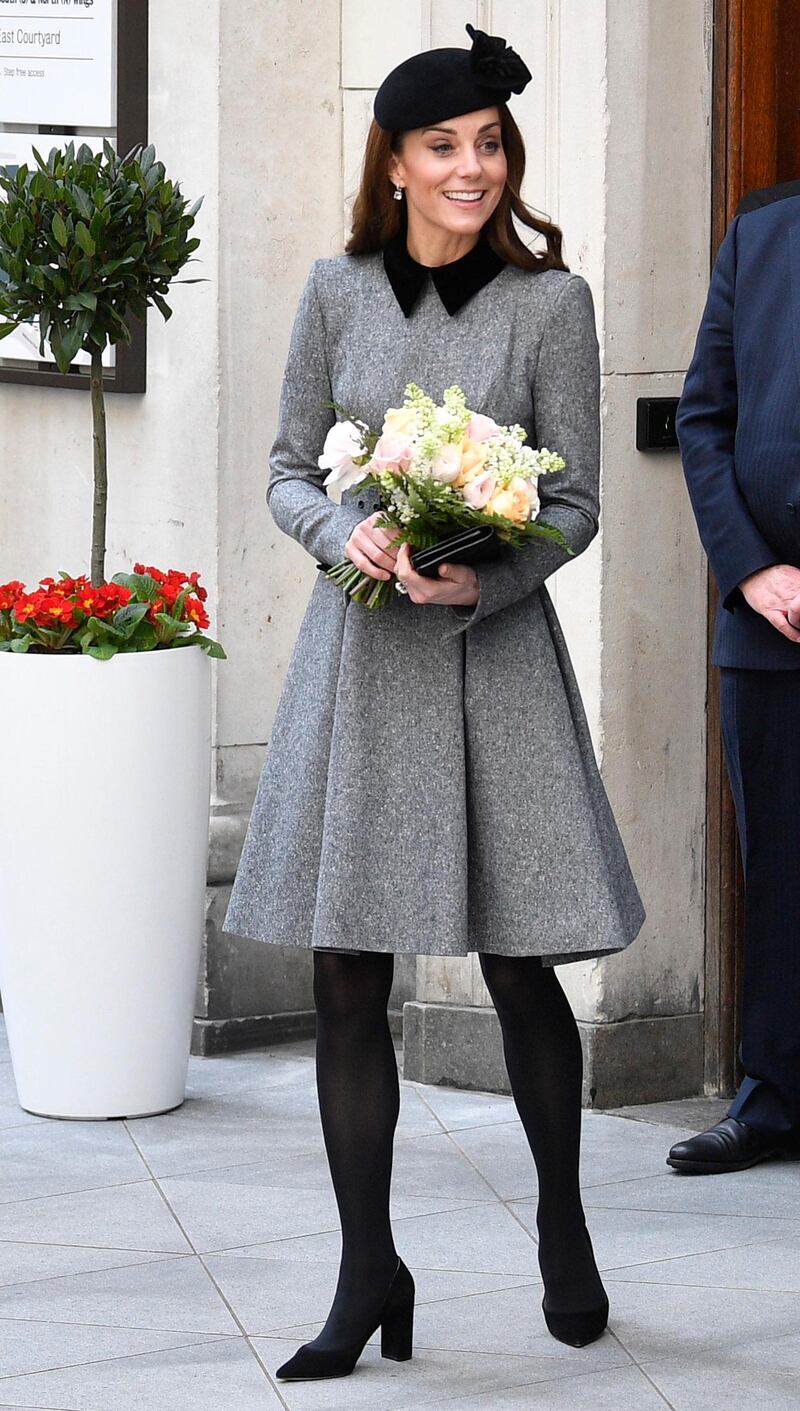 The Duchess of Cambridge wears a grey, belted Catherine Walker dress, with a Mulberry Bayswater clutch,  Gianvito Rossi Piper 85 suede pumps, Kiki McDonough earrings and a John Lock hat, which she has worn on a number of occasions in the past, as she arrives at a visit to Kings College in London with Queen Elizabeth II on March 19. EPA