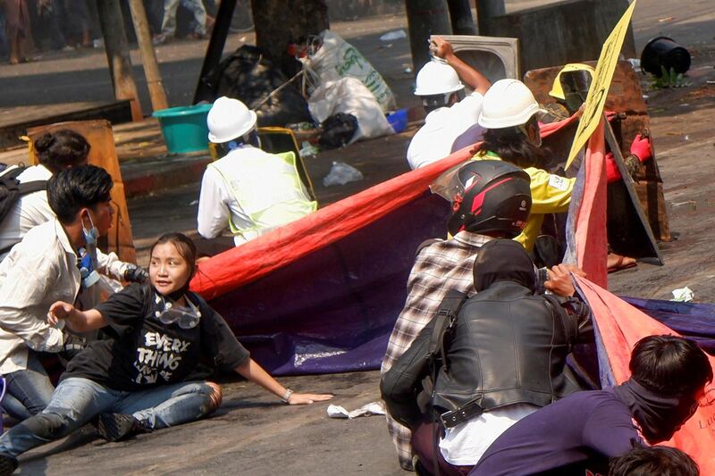 Protesters take cover after police open fire at an anti-coup demonstration in Mandalay, Myanmar. Teenager Kyal Sin, bottom left, was shot and killed. Reuters