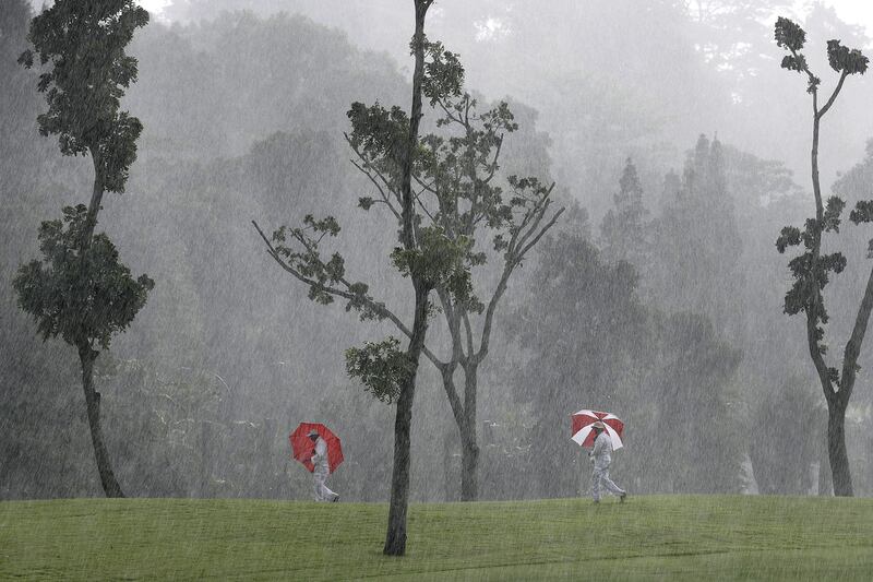 Course marshals carry umbrellas as they make their way towards shelter as a heavy downpour hit the HSBC Women’s Champions golf tournament at Sentosa Golf Club’s Tanjong course on March 3, 2017, in Singapore. Wong Maye-E / Associated Press