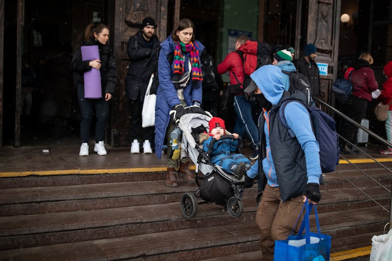 A couple carry their child out of the ticket hall at Lviv railway station.