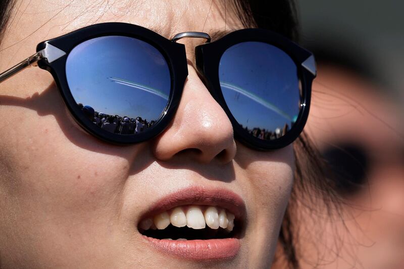 A visitor wearing sunglasses with the reflection of the China's K-8 aircrafts from the Aerobatic Team "Hongying", meaning Red Eagle, of Chinese PLA's (People's Liberation Army) Air Force. AP Photo