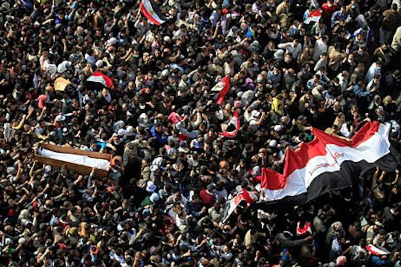 The body of a protester killed during clashes with police is carried through Tahrir Square during his funeral yesterday.