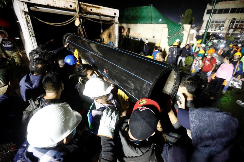 Workers carry a tube during the search for students at Enrique Rebsamen school after an earthquake in Mexico City. Edgard Garrido / Reuters