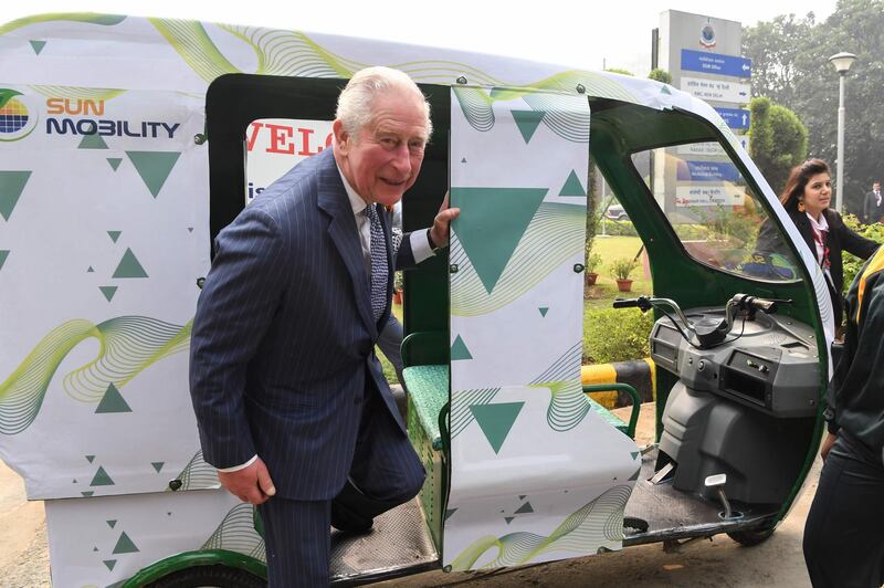 Prince Charles steps out after a ride in an electric rickshaw. AFP