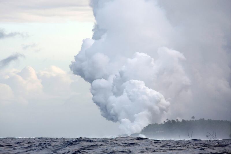 Steam and volcanic gases rise as lava flows into the Pacific Ocean southeast of Pahoa during ongoing eruptions of the Kilauea Volcano in Hawaii. Terray Sylvester / Reuters