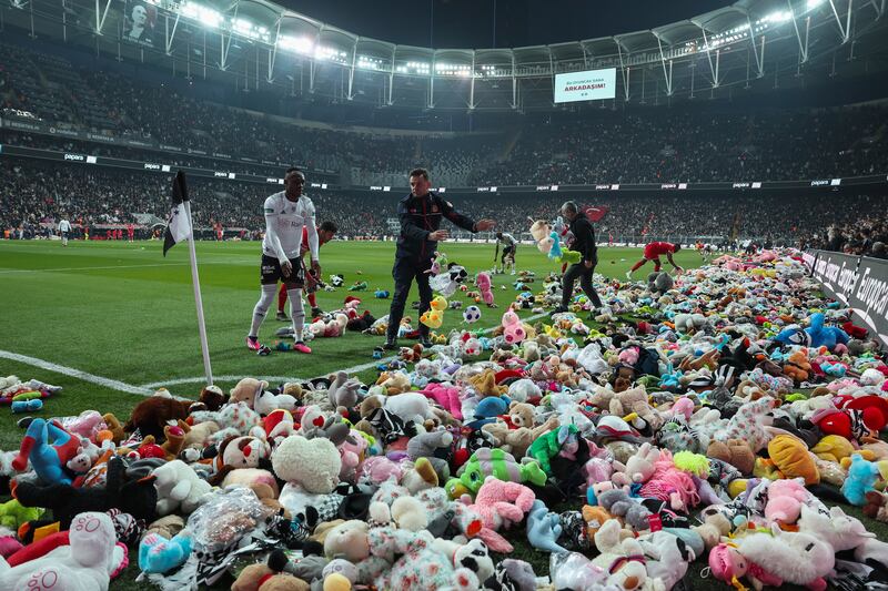 Fans throw toys onto the pitch during the Turkish Super League soccer match between Besiktas and Antalyaspor at the Vodafone stadium in Istanbul, Turkey, Sunday, Feb.  26, 2023.  During the match, supporters threw a massive number of soft toys to be donated to children affected by the powerful earthquake on Feb.  6 on southeast Turkey.  (AP Photo)