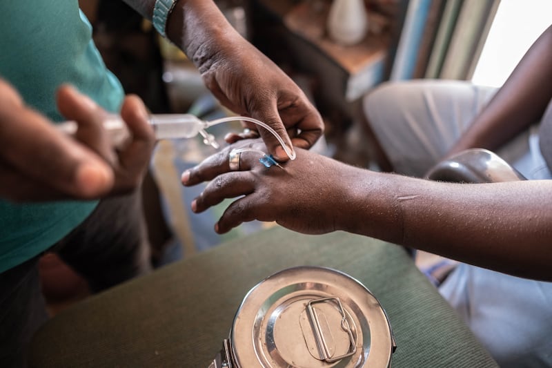 Antoine Bissa, a nurse and the owner of a street pharmacy is giving a anti malaria injection to a patient, in Bangui. AFP